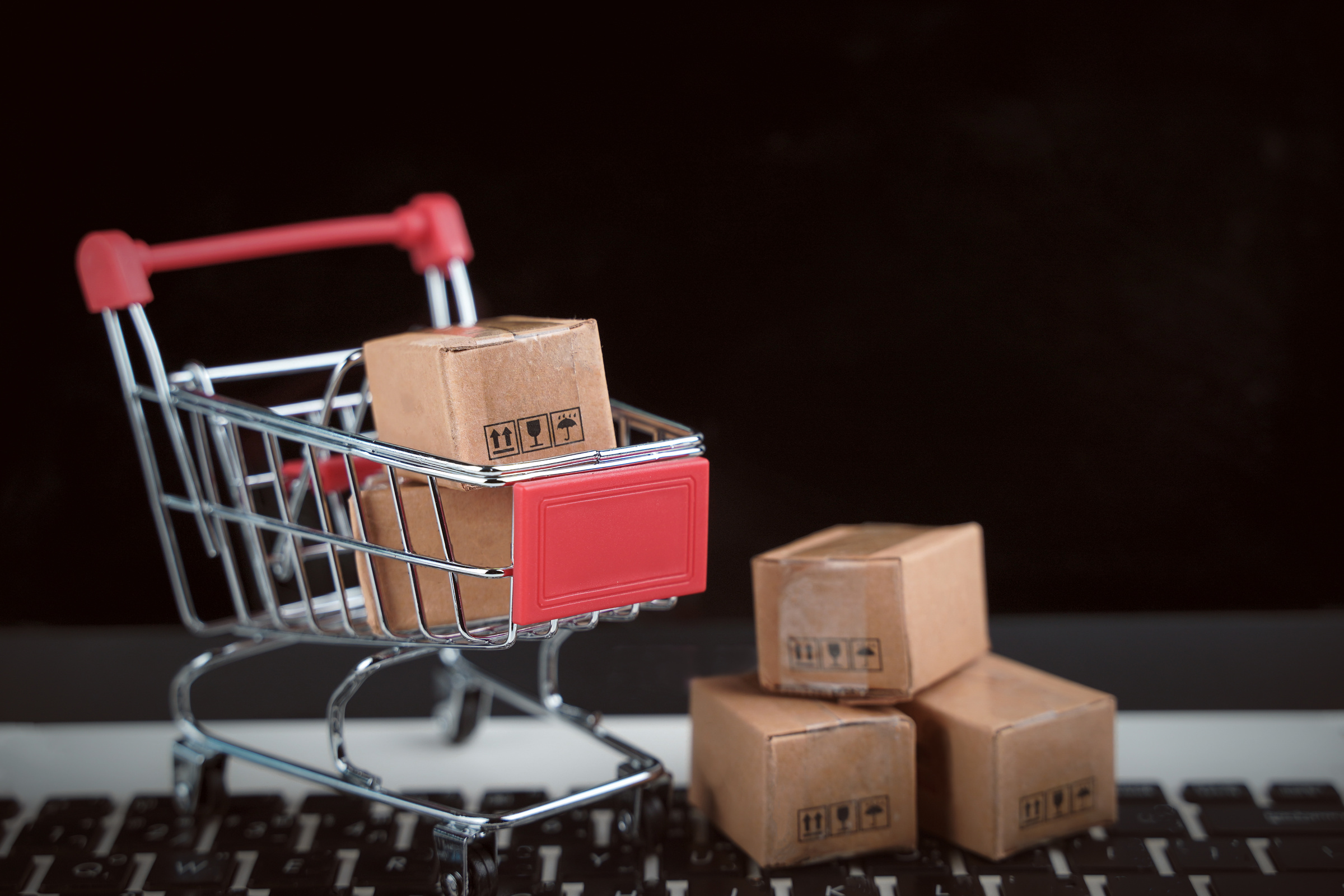 Shopping online concept. Trolley cart with cartons, e-commerce.